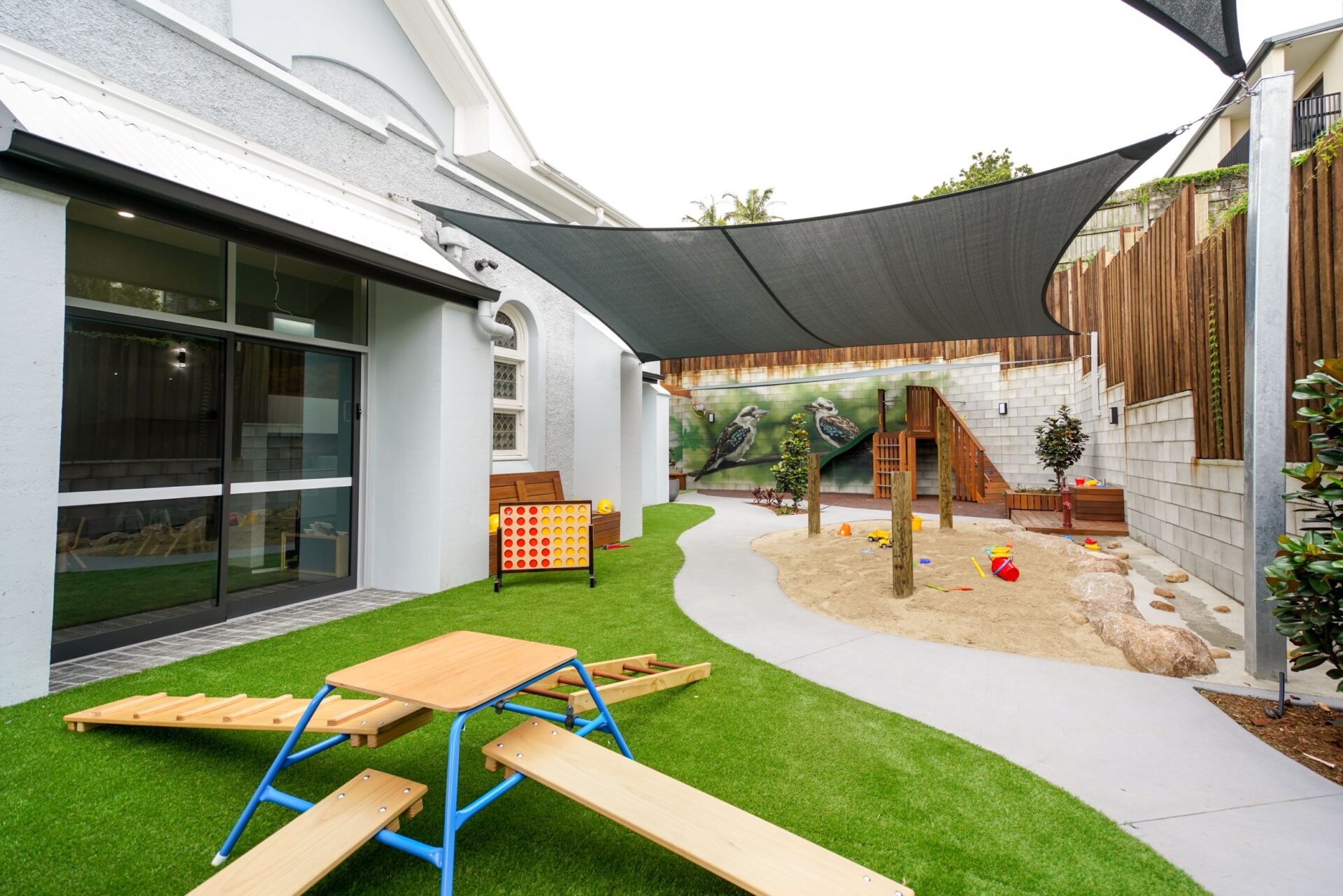 Grassy Outdoor Play Area With Playground And Sandpit at Little Locals Auchenflower Early Learning Centre in Brisbane.