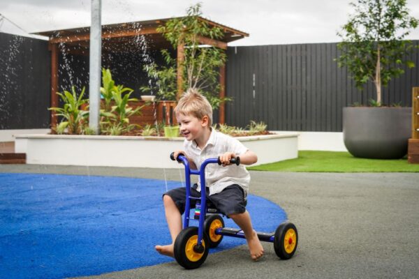 A child rides on a bike at Little Locals Early Learning Centres.